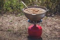 Making porridge on a gas burner in nature. Royalty Free Stock Photo