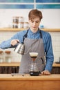 Making pourover coffee. Nice barista preparing coffee drink, looking concentrated. Royalty Free Stock Photo
