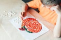 Making pumpkin from seeds on white paper, Halloween DIY concept