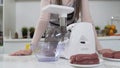 Making raw mincemeat with meat mincer at home. Pile of chopped meat. Electric mincer machine with fresh chopped meat Royalty Free Stock Photo