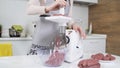 Making raw mincemeat with meat mincer at home. Pile of chopped meat. Electric mincer machine with fresh chopped meat