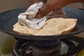 Making roti Indian Chapati on roti tawa made of wheat Royalty Free Stock Photo