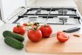 Making salad with tomato and cucumber in the kitchen