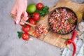 making salsa dip sauce - woman mixing chopped ingredients in wooden bowl