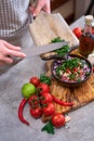 making salsa dip sauce - woman pouring chopped cilantro or parsley to wooden bowl