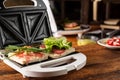 Making sandwiches from ham, vegetables and cheese in a sandwich maker. Two toasts with different fillings close-up Royalty Free Stock Photo