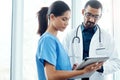 Making smart medical moves. two young doctors using a digital tablet in a modern hospital. Royalty Free Stock Photo