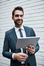 Making smart moves in a modern business world. a handsome young businessman using a digital tablet outdoors. Royalty Free Stock Photo