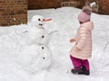 Young baby girl is making a snowman Royalty Free Stock Photo