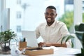 Making some updates to his files. Portrait of a young businessman working on a laptop in an office. Royalty Free Stock Photo