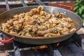 Making spanish traditional valencian Paella stir-frying Rabbit meat, Artichokes and Green Beans. Royalty Free Stock Photo