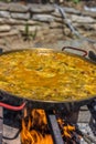 Making spanish traditional valencian Paella stir-frying Rabbit meat, Artichokes and Green Beans. Royalty Free Stock Photo