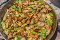 Making spanish traditional valencian Paella stir-frying Rabbit meat, Artichokes and Green Beans. Royalty Free Stock Photo