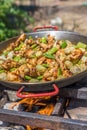 Making spanish traditional valencian Paella stir-frying Rabbit meat, Artichokes and Green Beans. Royalty Free Stock Photo
