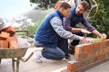 Making strong foundations - Teaching the basics. Shot of bricklayers at work. Royalty Free Stock Photo
