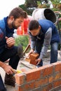 Making strong foundations together. Shot of bricklayers at work. Royalty Free Stock Photo