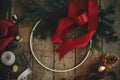 Making stylish modern christmas wreath flat lay. Fir branches, round wooden hoop, red ribbon, candle and pine cones on rustic Royalty Free Stock Photo