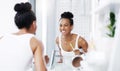 Making sure I have the brightest smile today. an attractive young woman brushing her teeth while looking at the bathroom