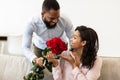 Young black man giving red roses to woman Royalty Free Stock Photo