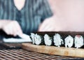 Making Sushi Rolls at Home: Rolls Sealing On the Wooden Board before Slicing. Blurred Woman Hands Spreading Rice across the Nori Royalty Free Stock Photo