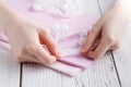 Making table decorations. A shot of woman sewing a natural beige linen tablecloth, towels and napkins with rose print and a croche Royalty Free Stock Photo