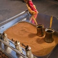 Making traditional Turkish coffee on sand. Two Cezve and hand mills with authentic Turkish coffee on hot sand