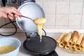 Making waffles at home - waffle iron, batter in bowl and ingredients - milk, eggs and flour. Cooking background. Royalty Free Stock Photo