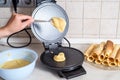 Making waffles at home - waffle iron, batter in bowl and ingredients - milk, eggs and flour. Cooking background. Royalty Free Stock Photo