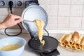 Making waffles at home - waffle iron, batter in bowl and ingredients - milk, eggs and flour. Cooking background. Royalty Free Stock Photo