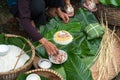 Making wrapping Chung Cake, the Vietnamese lunar new year Tet food outdoor with old woman hands and ingredients. Closed-up.