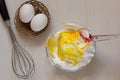 Making yellow colored whipped egg whites in glass bowl. top view Royalty Free Stock Photo