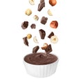 Making yummy chocolate paste. Hazelnuts and pieces of chocolate falling into bowl on white background Royalty Free Stock Photo