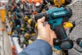 Makita cordless power drill. A man in a hardware store chooses a new drill or screwdriver. Minsk, Belarus, 2022