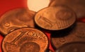 Makro close up of pile one and two euro cent copper coins on shiny red background Royalty Free Stock Photo