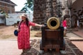 Malacca, Malaysia - February 28, 2019: Asian tourist puts her hand on old canon in Malacca old city.