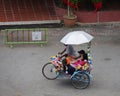 Malacca, Malaysia--February 2018: Downward shot of a colorful flower-decorated trishaw with two passengers at the Dutch Square in