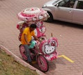 Malacca, Malaysia--February 2018: Downward shot of a man driving a colorful trishaw decorated with the Hello Kitty theme at the