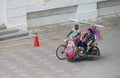 Malacca, Malaysia--February 2018: A man pedals a flower-decorated trishaw with a female passenger at the Dutch Square in Melaka, Royalty Free Stock Photo