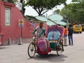 Malacca, Malaysia--February 2018: Wide shot of a colorful trishaw along the brick-paved Dutch Square in Melaka, Malaysia with