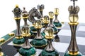 Malachite stone chess pieces on and marble chessboard