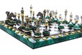 Malachite stone chess pieces on and marble chessboard