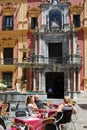 Tourists relaxing at pavement cafes in Obispo Square, Malaga, Spain.