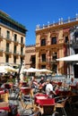 Tourists relaxing at pavement cafes in Obispo Square, Malaga, Spain.