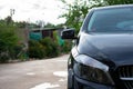 Black Mercedes-Benz Class A in a photoshoot. Freshly washed and wet Mercedes-Benz parked in a courtyard. Royalty Free Stock Photo