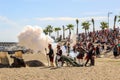 18th century french soldiers firing a cannon with gunpowder. Men and women reenactors