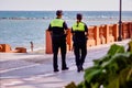 Malaga, Spain - September 04, 2015: Rear view of police security by the beach wearing cap in summer Royalty Free Stock Photo