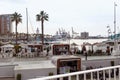 Malaga, Spain- 26-01-2024: Vibrant scene at Puerto de Malaga with outdoor cafes, palm trees, and yachts, a perfect Royalty Free Stock Photo