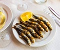 Close up of Andalusian fried sardines on white plate on white tablecloth