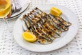 Close up of Andalusian fried sardines on white plate on white tablecloth