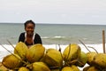 Malagasy woman selling coconuts on the beach
